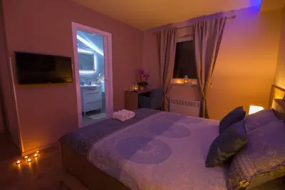 a bedroom with a bed with a purple comforter at Gradiska na Savi apartmani i sobe in Bosanska Gradiška