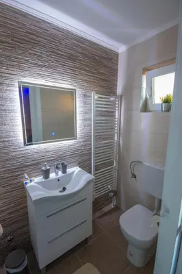 a bathroom with a sink and a toilet and a mirror at Gradiska na Savi apartmani i sobe in Bosanska Gradiška
