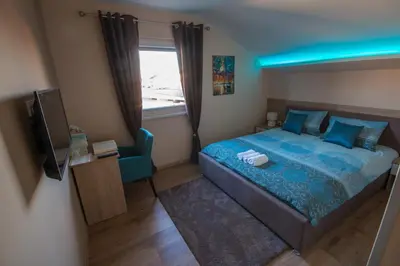 a bedroom with a bed and a tv and a window at Gradiska na Savi apartmani i sobe in Bosanska Gradiška