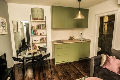 a kitchen with green cabinets and a table in a room at Polar Apartments Banja Luka LPIJ in Banja Luka