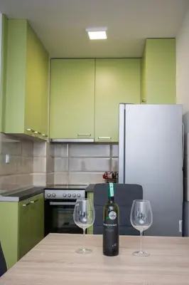 a kitchen with a bottle of wine and two wine glasses at Stan na dan Doboj in Doboj