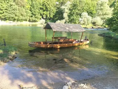 a wooden boat with a roof on a river at EMRAH RIVER UNA in Bihać