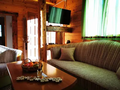 a living room with a couch and a table at Wooden House 