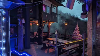 a room with a christmas tree on a porch at tree house in Visoko