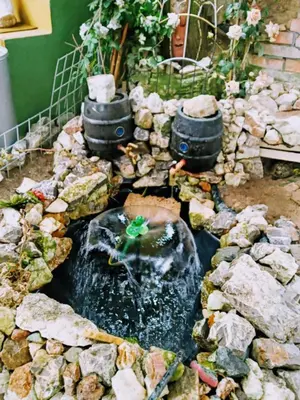 a model of a pond with rocks and buckets at tree house in Visoko