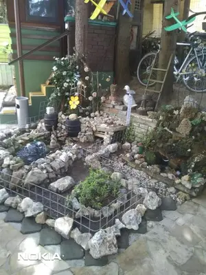 a garden with rocks and plants in front of a building at tree house in Visoko