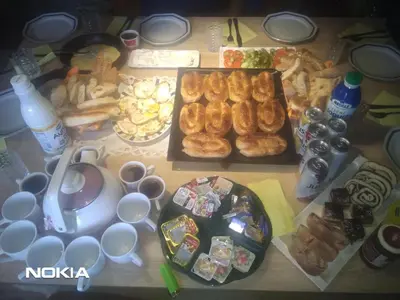 a table topped with lots of different types of food at tree house in Visoko