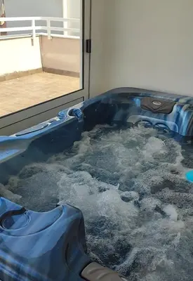 a blue tub filled with water next to a window at Spa apartman Iva in Banja Luka