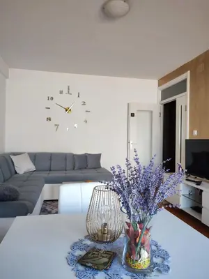 a living room with a vase of purple flowers on a table at Spa apartman Iva in Banja Luka