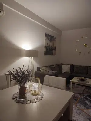 a living room with a table and a couch at Spa apartman Iva in Banja Luka