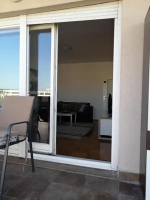 a sliding glass door leading to a living room at Spa apartman Iva in Banja Luka