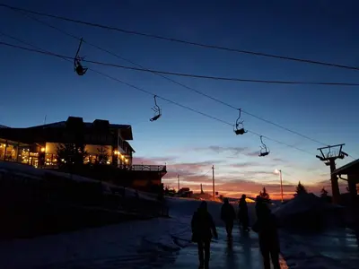 a group of people walking under a ski lift at night at Vlasicka avantura Eko Fis 509 in Vlasic