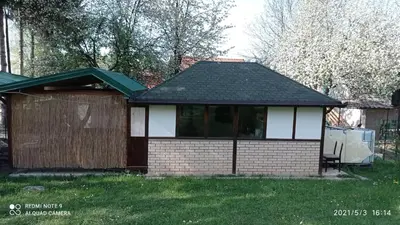 a small house with a roof on a yard at Ravne Apartman 2 in Visoko