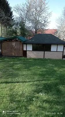 a house with a green yard with a fence at Ravne Apartman 2 in Visoko