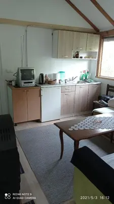 a kitchen with a tv and a table in a room at Ravne Apartman 2 in Visoko