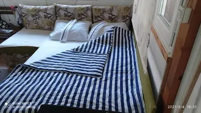 a bed with blue and white sheets and pillows at Ravne Apartman 2 in Visoko
