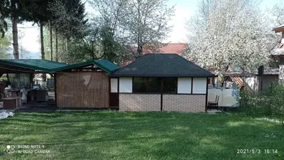 a house with a garage in a yard at Ravne Apartman 2 in Visoko