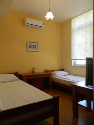 a hotel room with two beds and a window at Pansion Centar in Tuzla
