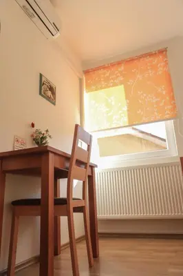 a table and chair in a room with a window at Pansion Centar in Tuzla