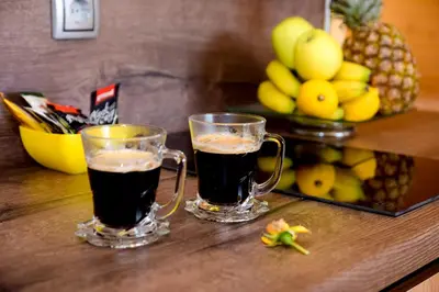 two glasses of coffee sitting on a table with fruit at Cottage Lana in Jajce