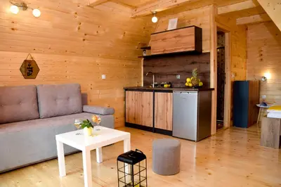 a living room with a couch and a kitchen at Cottage Lana in Jajce