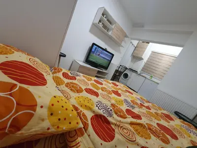 a bedroom with a bed with a colorful bedspread at Garsonjera u centru Prnjavor in Prnjavor