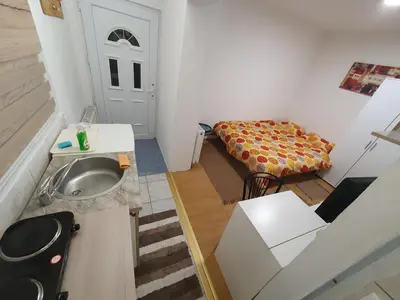 a small bathroom with a sink and a couch at Garsonjera u centru Prnjavor in Prnjavor