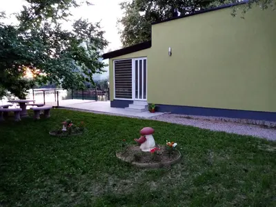 a garden with a statue of a dog in the grass at Apartman Dzenis in Bihać