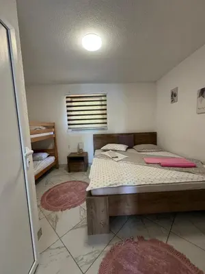 a bedroom with a bed in a room with rugs at Apartman Dzenis in Bihać