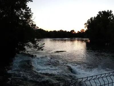 a body of water with a fence next to it at Apartman Dzenis in Bihać