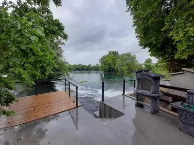 a flooded deck next to a body of water at Apartman Dzenis in Bihać