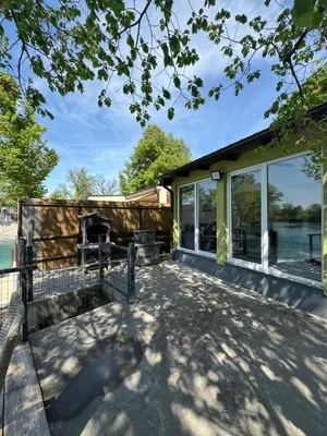 a house with a deck with a view of the water at Apartman Dzenis in Bihać