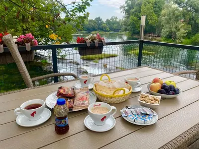 a table with cups and plates of food and drinks at Apartman Dzenis in Bihać
