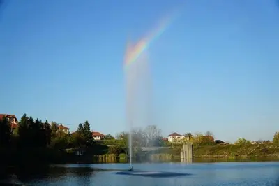 a rainbow in the middle of a lake with a fountain at Sobe Lara in Gradačac