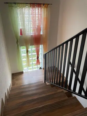 a staircase leading to a window with curtains at Sobe Lara in Gradačac
