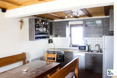 a small kitchen with a table and a refrigerator at Adria in Kupres