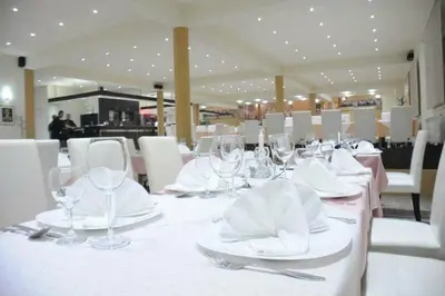 a table with white plates and wine glasses on it at Motel OAZA in Cazin