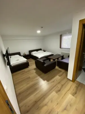a room with two beds and a couch and a table at Motel OAZA in Cazin