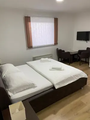 a bedroom with a bed and a table with chairs at Motel OAZA in Cazin