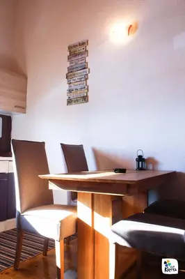 a dining room table with chairs and books on the wall at Apartman Adria 2 in Kupres