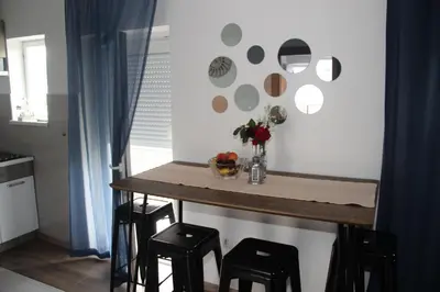 a small kitchen with a table and stools at Apartman ANA Livno - biker friendly in Livno