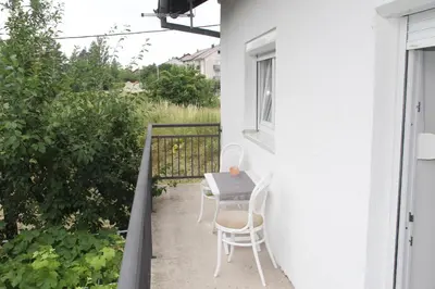 a table and chairs on the balcony of a house at Apartman ANA Livno - biker friendly in Livno