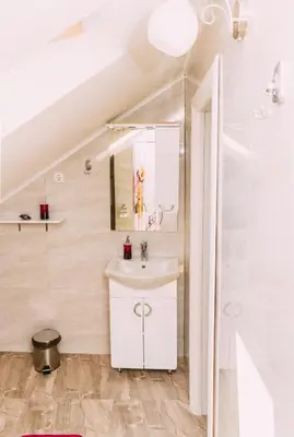 a white bathroom with a sink and a mirror at Apartmani Markešić Ramsko jezero in Prozor