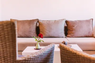 a living room with a couch and a vase with a flower on a table at Apartmani Markešić Ramsko jezero in Prozor