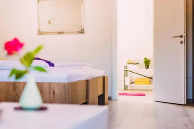 a white room with a bed and a mirror at Apartmani Markešić Ramsko jezero in Prozor