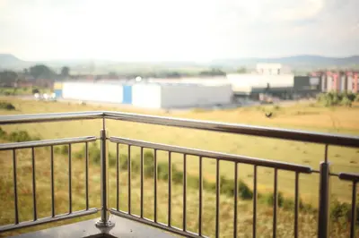 a balcony with a view of a field and buildings at Apartment Perviz in Bihać