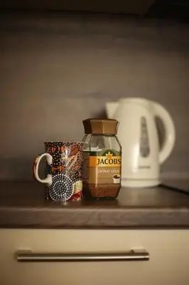 a counter with a jar of food and a coffee mug at Apartment Perviz in Bihać