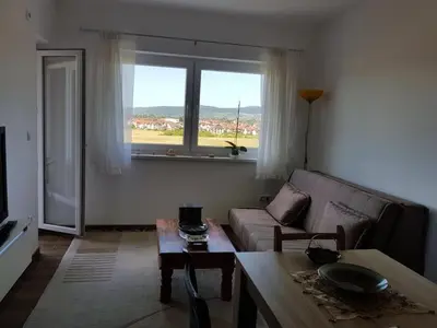 a living room with a couch and a table and a window at Apartment Perviz in Bihać
