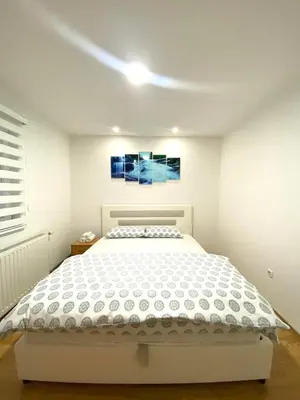 a bedroom with a white bed in a room at Apartmani GO Bugojno in Bugojno