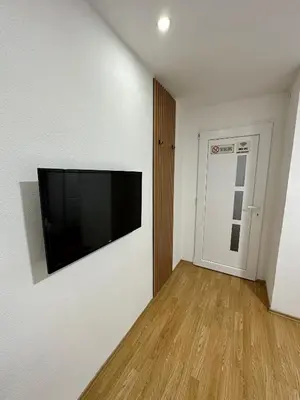 a living room with a flat screen tv on a wall at Apartmani GO Bugojno in Bugojno
